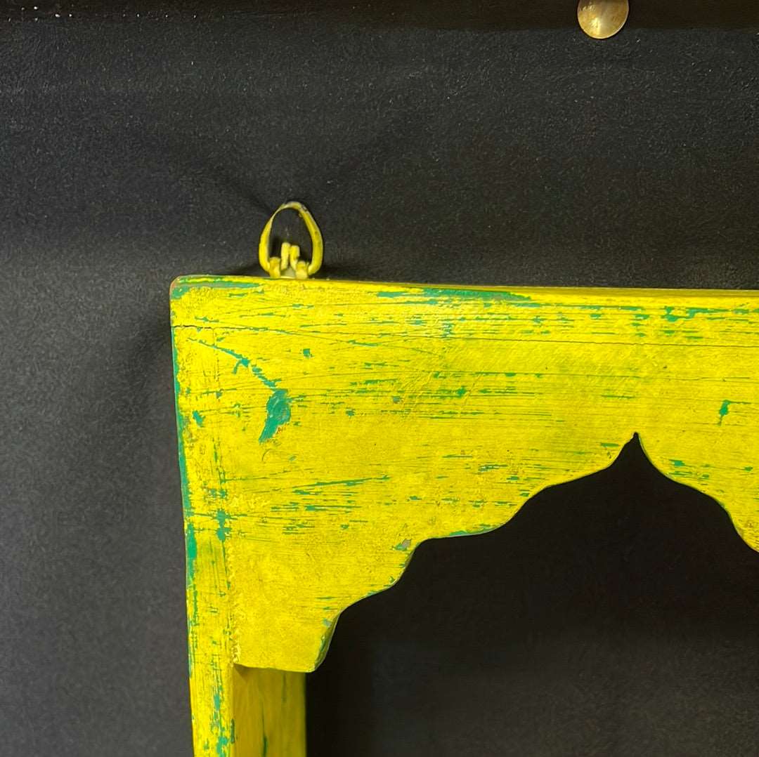 Single Indian wooden temple arch shelf yellow distressed finish.