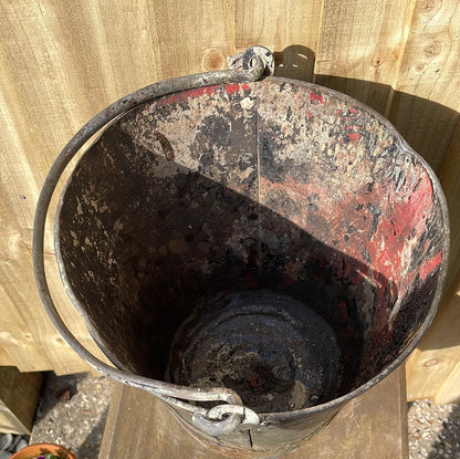 Rustic galvanised bucket planter with black paint splashes.