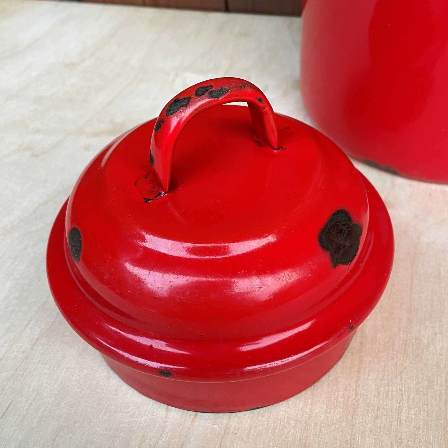 Red enamelled churn container with lid.