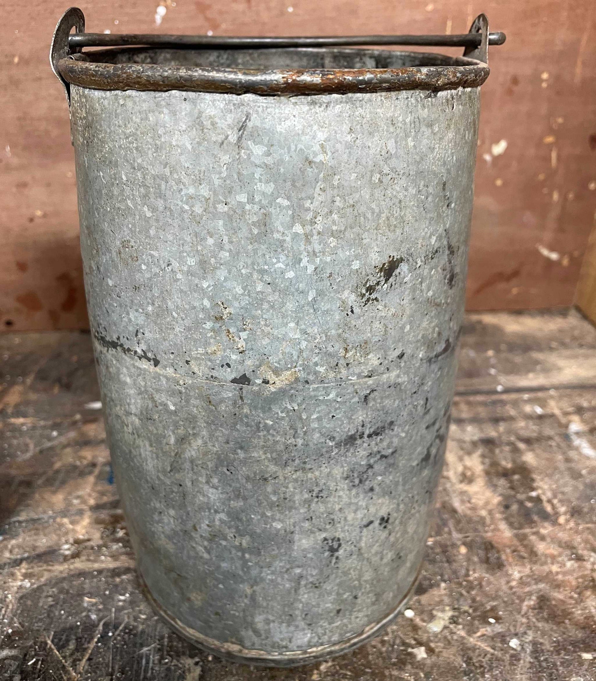 Metal planter bucket with handle.