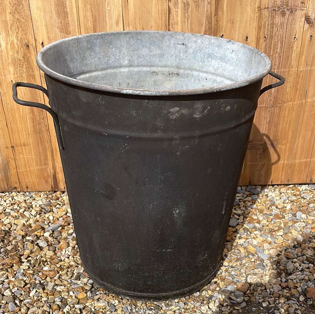 Rustic round galvanised bin garden planter with black aged paint.