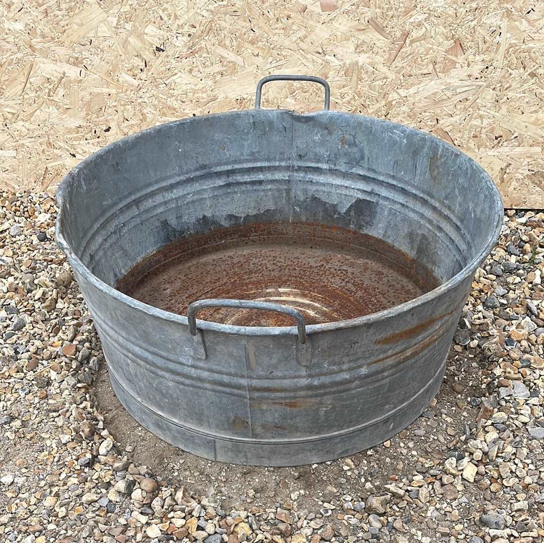 Round straight sided shallow galvanised tub planter with two handles.