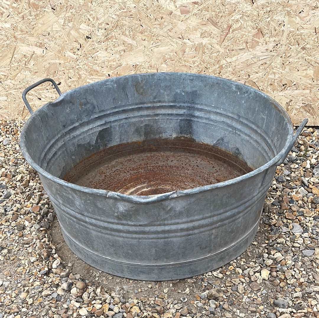 Round straight sided shallow galvanised tub planter with two handles.