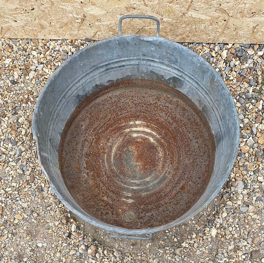 Round straight sided shallow galvanised tub planter with two handles.