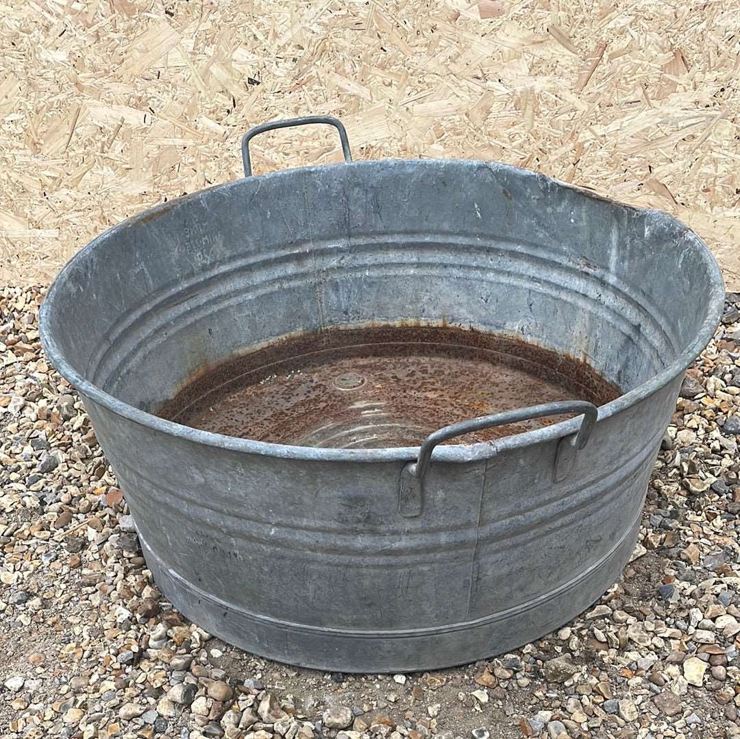 Round straight sided shallow galvanised tub planter with two handles.